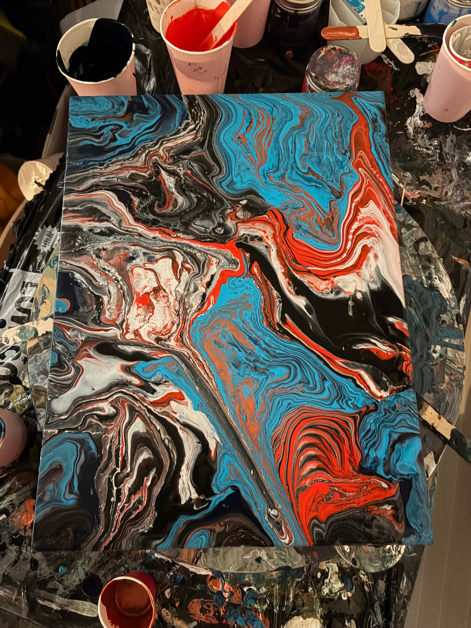 Blue, red, black and white acrylic pour painting with cells, made by a Handy Mandy customer