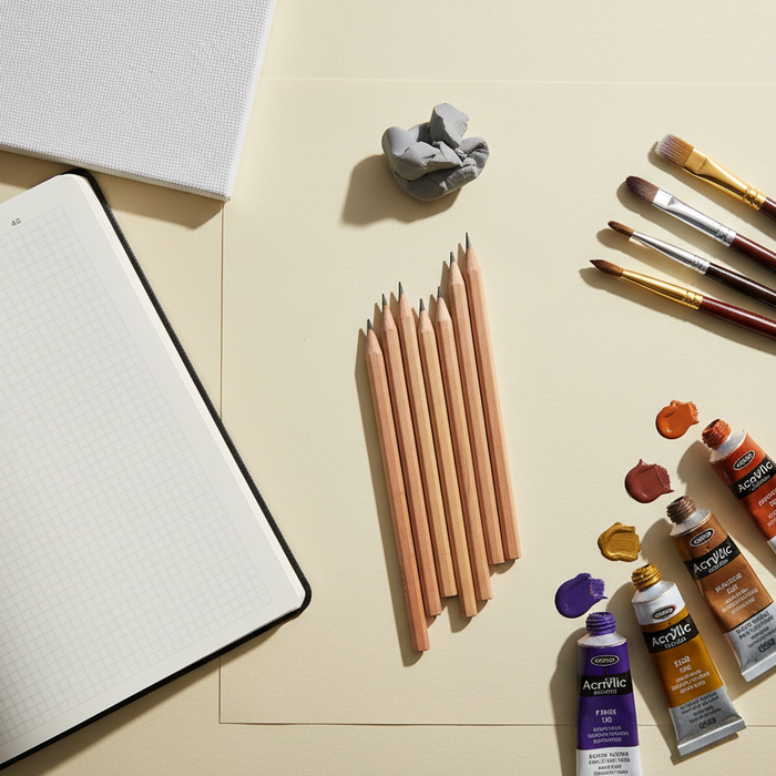 Flat lay of NCEA art kit contents: drawing pencils, taklon brushes, acrylic paint tubes and an A3 pad